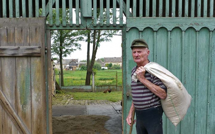 Peter Trendler mit Holzspänen für den Winter kann das Wirtschaften nicht lassen. Im Hintergrund brachliegende Hausgärten seines Viertels, der 85-jährige kann sich das nicht erklären